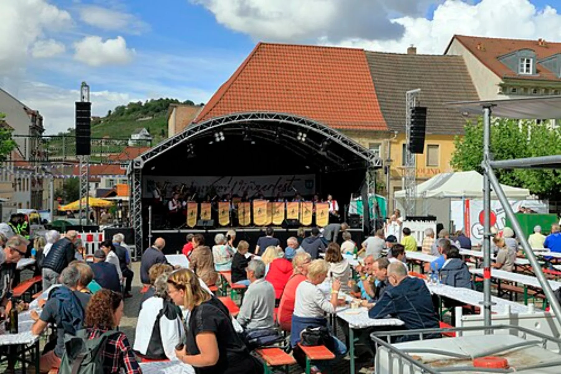 Gäste an langen Tischen auf dem Marktplatz von Freyburg beim Winzerfest